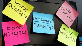 Sticky notes on a monitor displaying assorted passwords