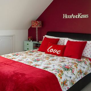 bedroom with cushions on bed and red cosy blanket