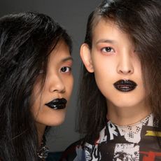two models wearing black lipstick