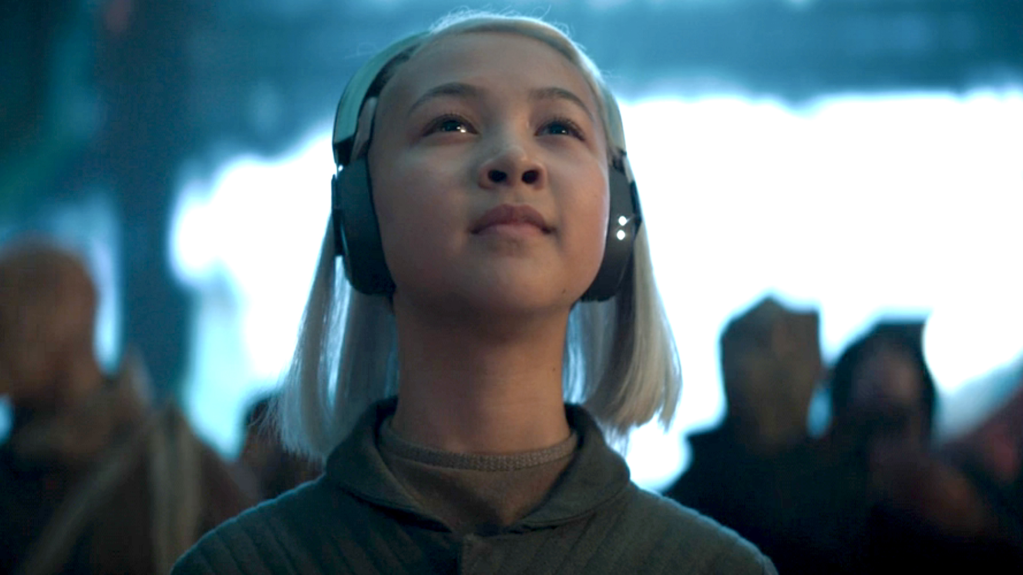 Kyriana Kratter as KB wears large headphones and looks upward in Star Wars: Skeleton Crew.