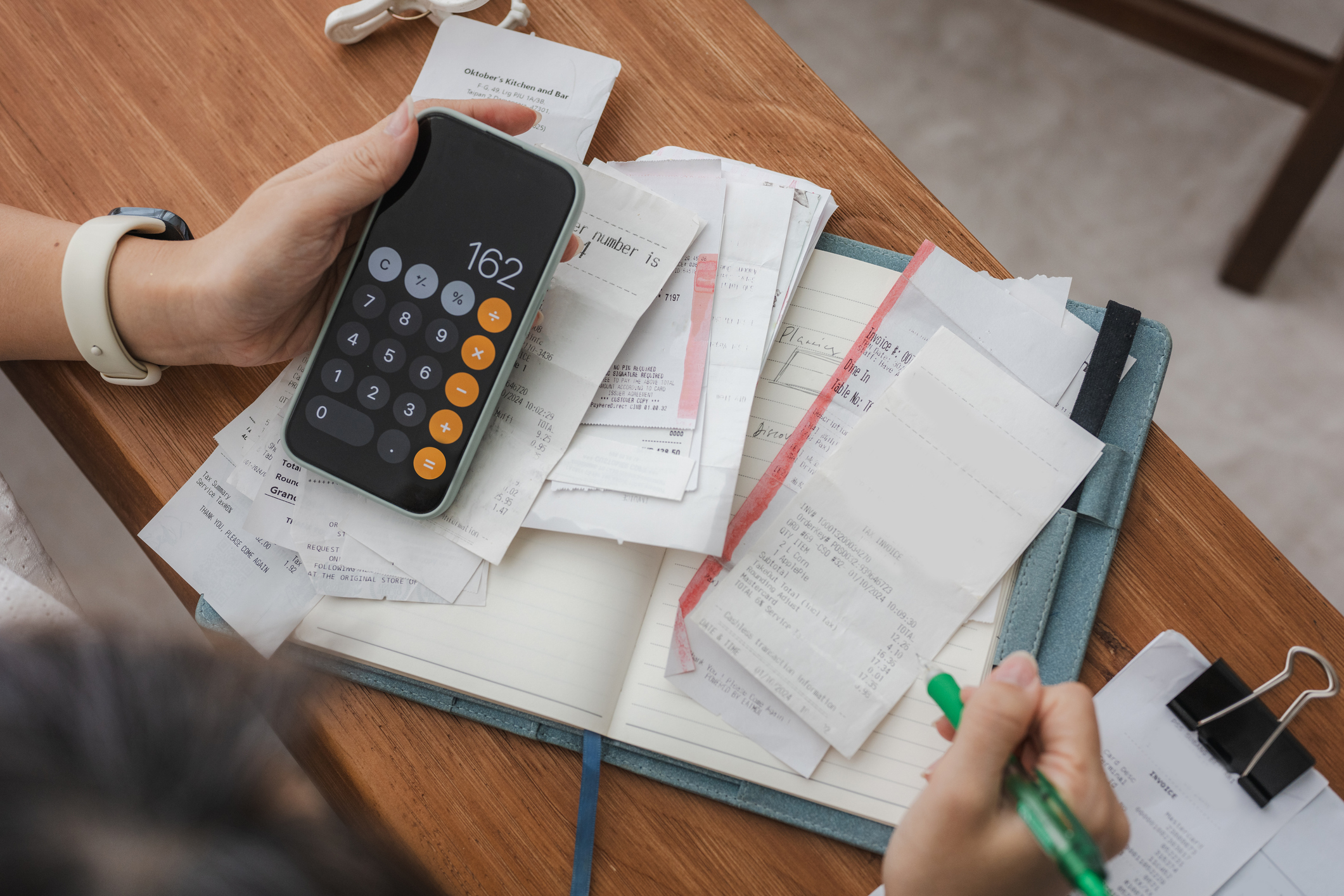 Close up a woman managing her home finances with a smartphone
