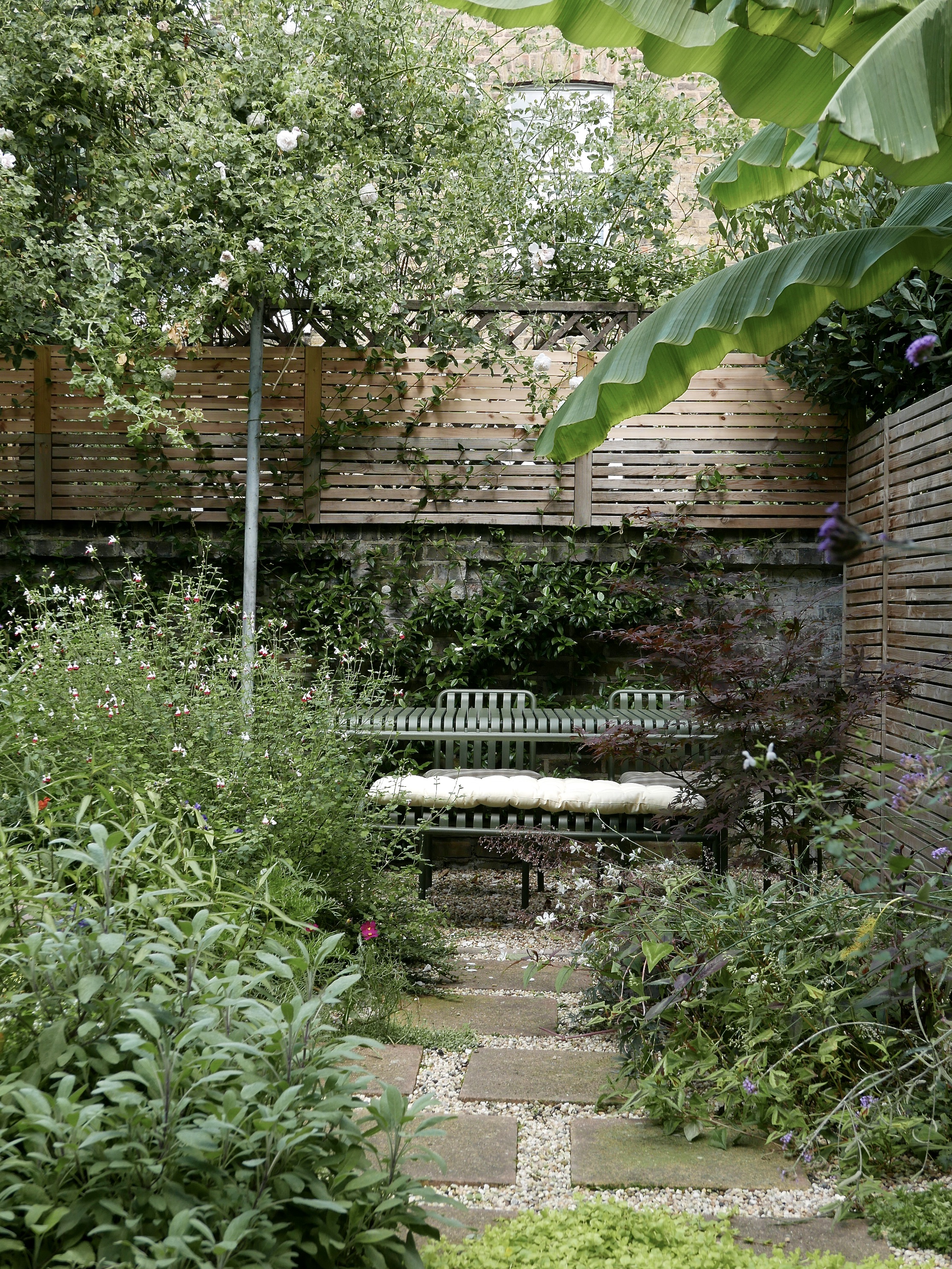 Leafy urban garden with HAY Palissade outdoor furniture in green