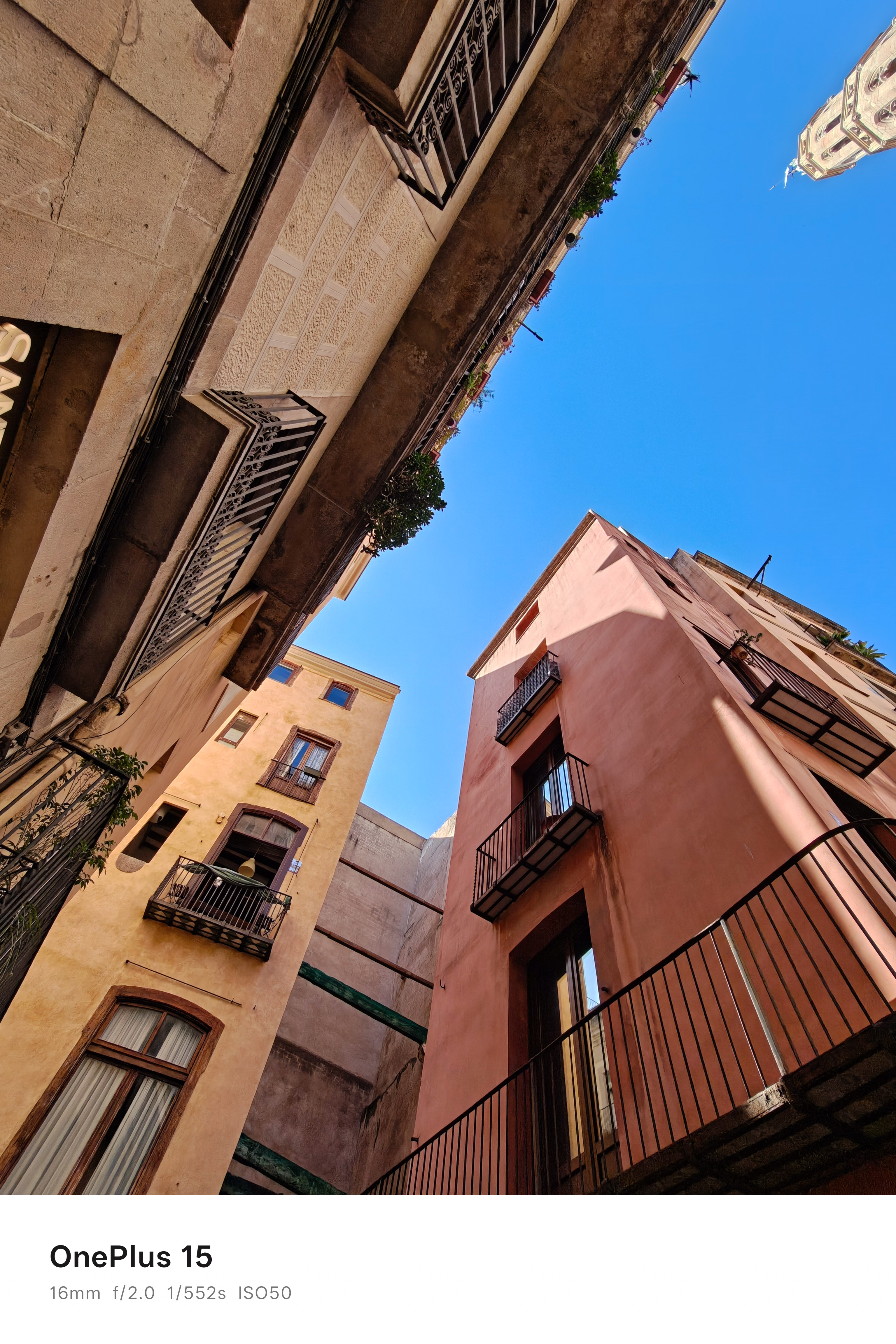 View upwards of the sky between narrow residential buildings in Barcelona, Spain