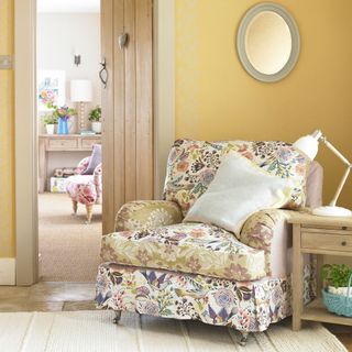 living area with yellow floral sofa and sidetable and rug