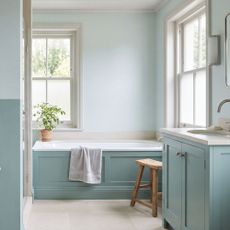 Bathroom with bath and lower half of walls painted aquamarine, and the top half a paler version