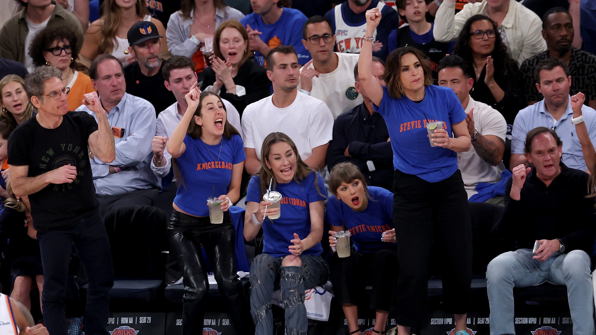 (L to R) Ben Stiller, Alana Haim, Este Haim, Taylor Swift, and Mariska Hargitay attend Game Four of the 2026 NBA Finals. The Haims, Swift and Hargitay are wearing matching shirts.