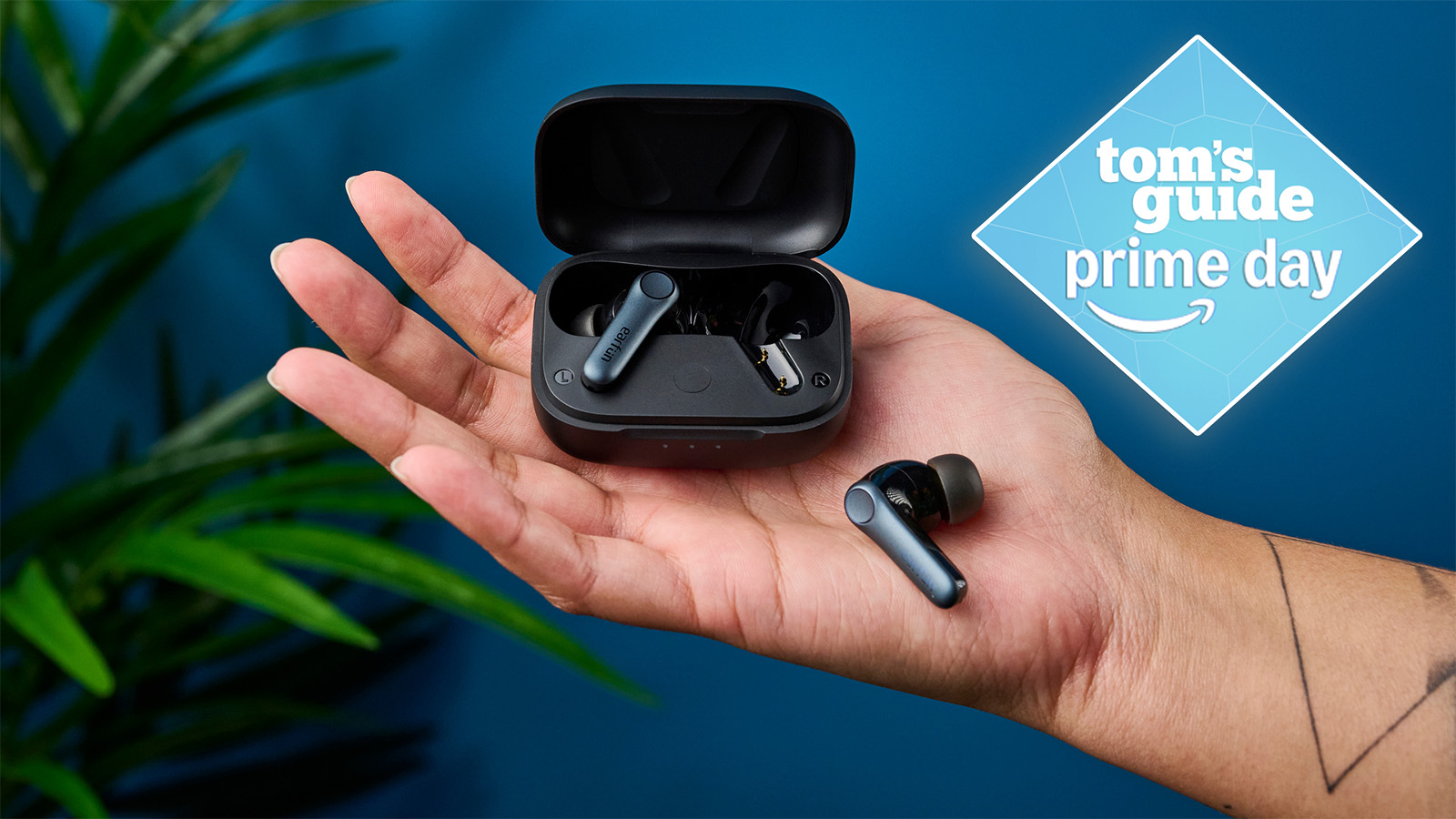 the earfun air pro 4 earbuds photographed being held with one earbud in the charging case, one outside, with a tom&#039;s guide prime day deal badge