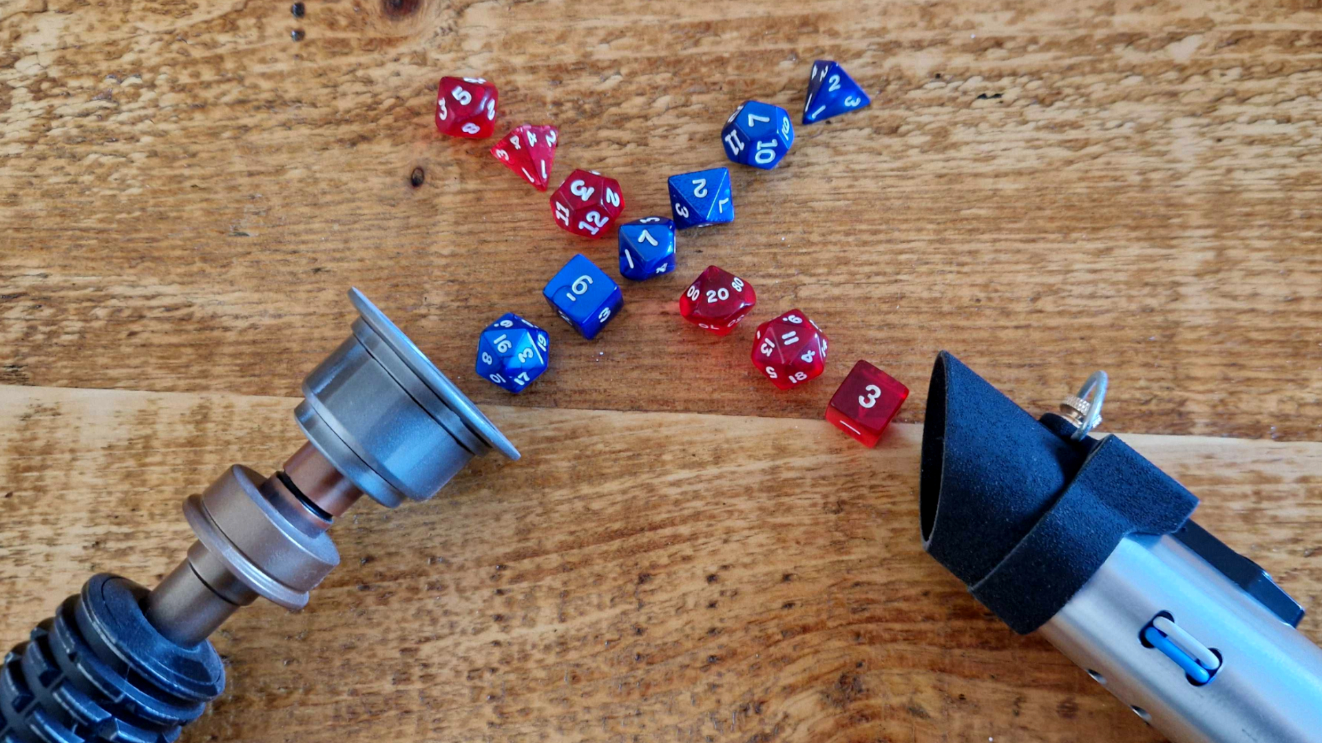 Two crossed lightsaber hilts with 'dice' blades on a wooden table