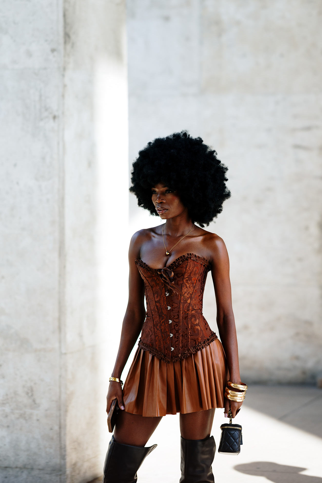 a woman with an afro wearing a red bustier and a tan skirt