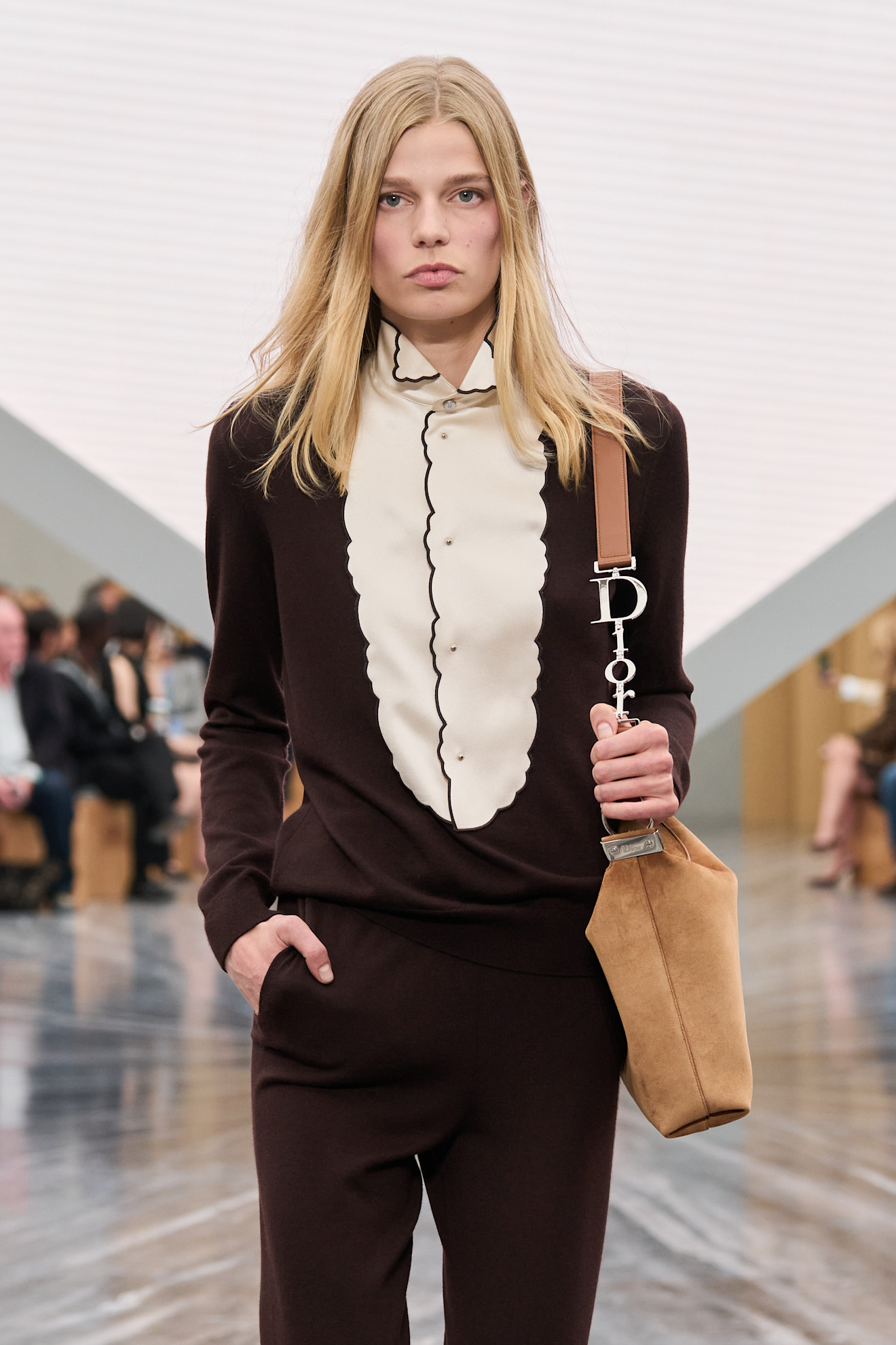 a model carries the dior diorly bag on the runway.