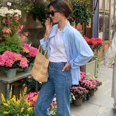 Woman in blue button-down, jeans, and white tee