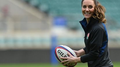 Britain's Catherine, Duchess of Cambridge runs with the ball as she takes part in the England's rugby teams training sessions at the Twickenham Stadium, in London