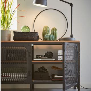 white wall with black storage cabinet lamp and pot