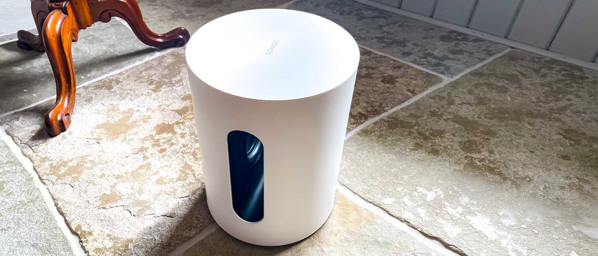 Sonos Sub Mini in white placed on stone floor