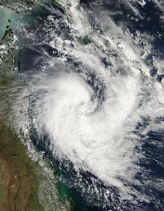 NASA's Aqua satellite captured a visible image of newborn Tropical Cyclone Tim in the Coral Sea on March 14, 2013 at 04:05 UTC (12:05 a.m. EDT). Note the large band of thunderstorms wrapping into the center from the south and east.
