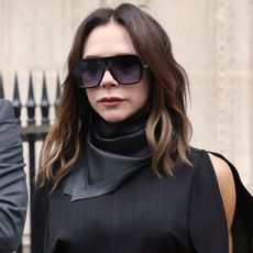 Victoria Beckham wears oversize sunglasses and a black dress