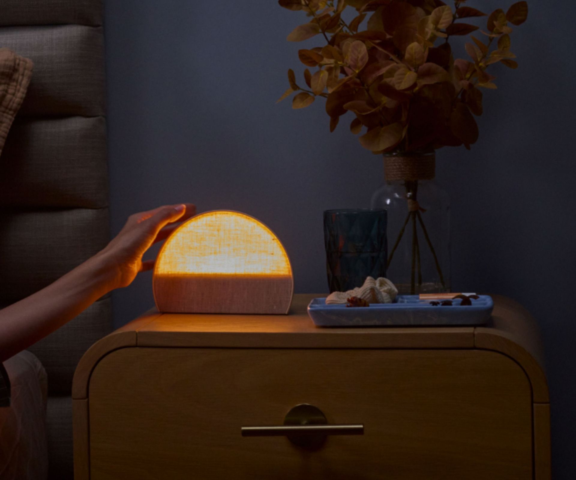 A Hatch Restore 2 Sunrise Alarm clock on a bedside table