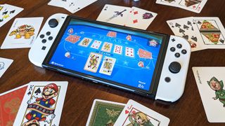 Nintendo Switch OLED surrounded by playing cards