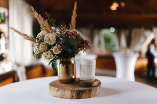 Scented candle and bouquet of dry flowers on table