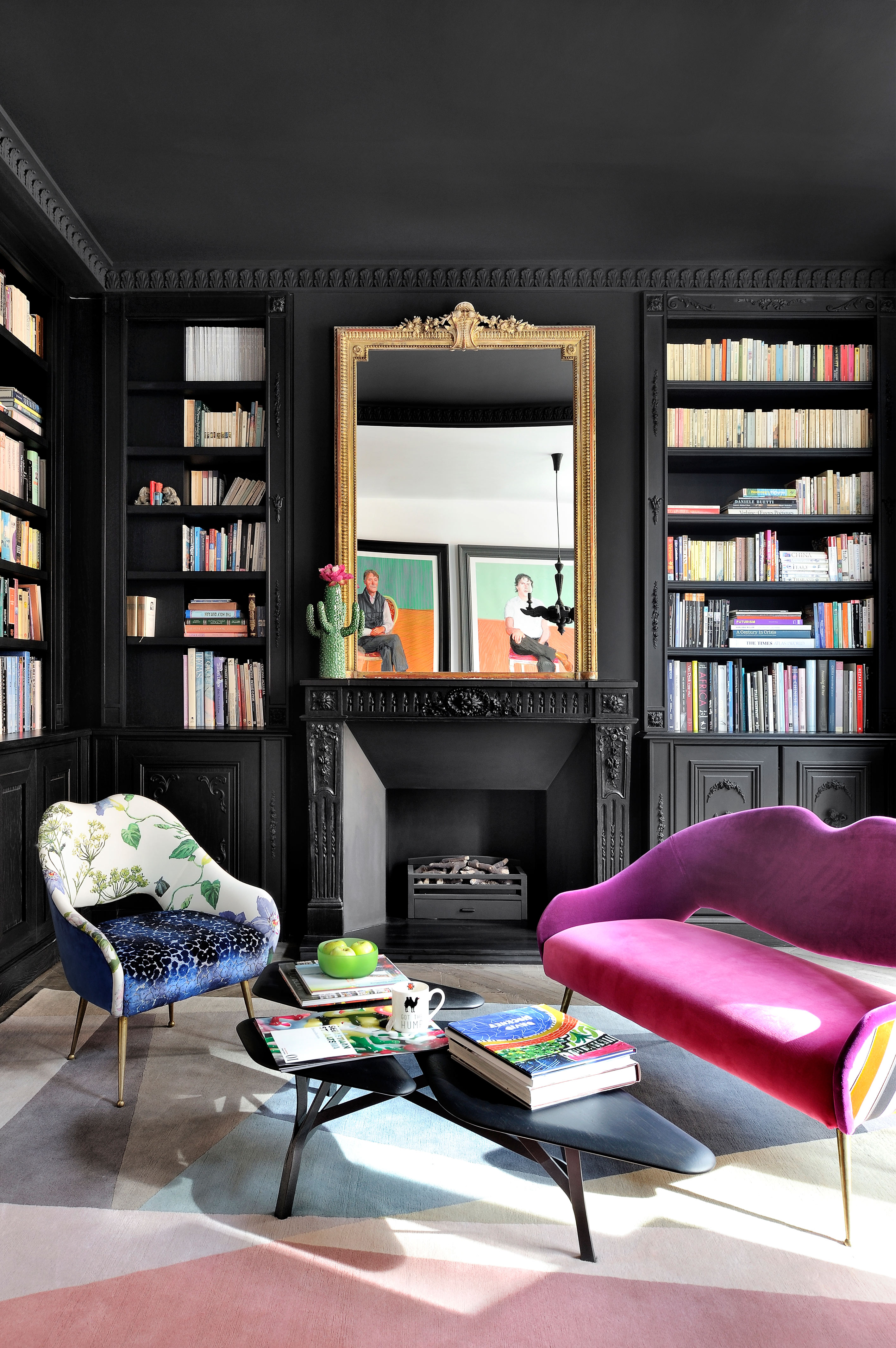 Black living room with painted ceiling, book cases and colorful carpet