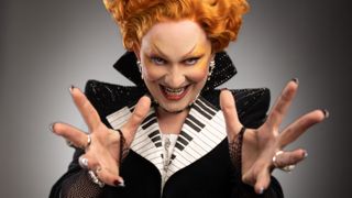 Jinkx Monsoon in costume for Doctor Who staring down the lens menacingly with hands outstretched