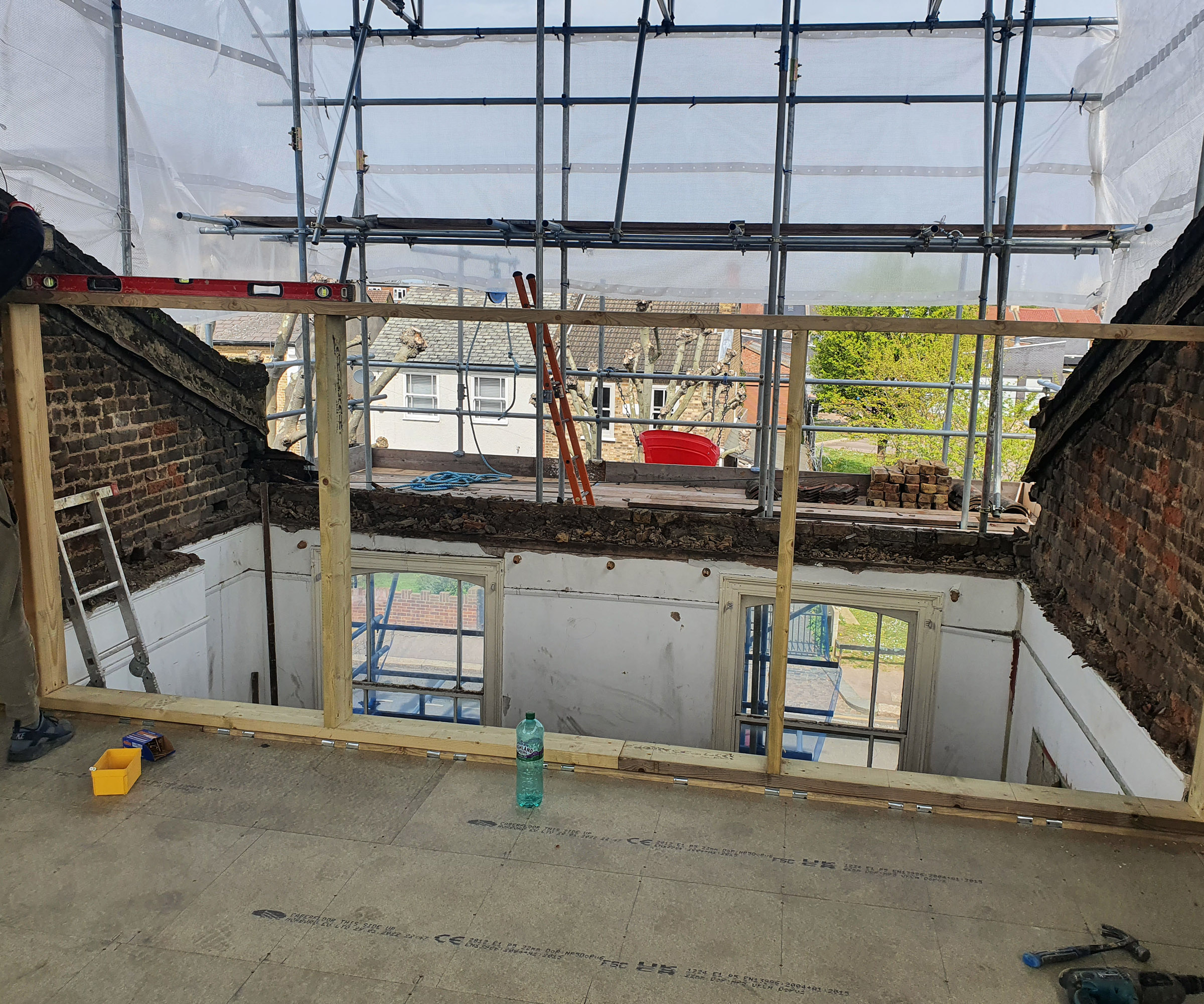 A loft conversion taking shape with scaffolding and no roof