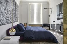 Best mattress hero image: a luxury bedroom with a purple bed and statement lighting