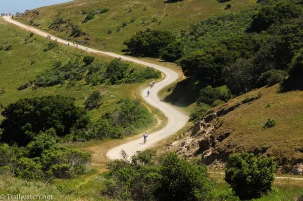Racers ride a fireroad on the back of the course