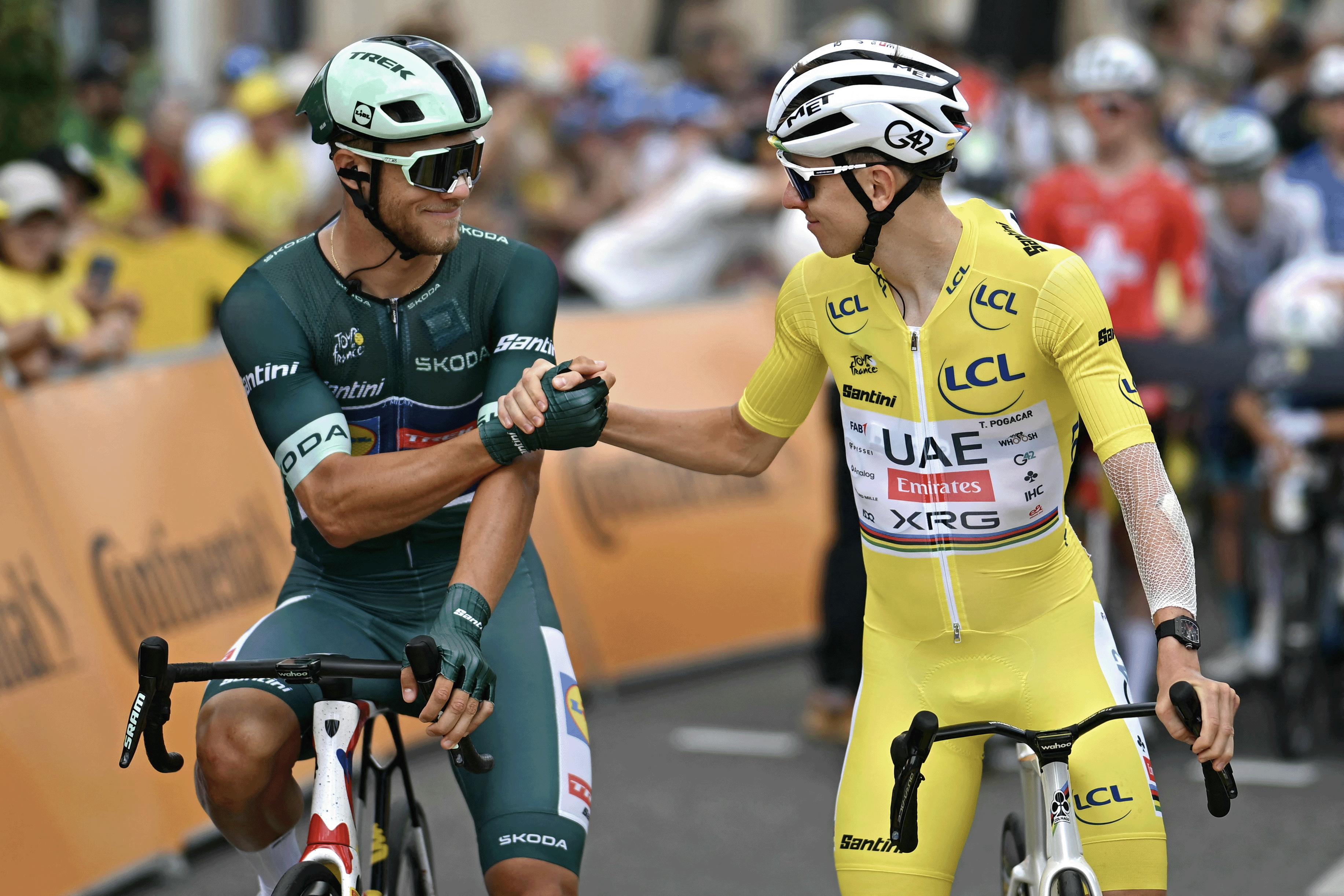 (From L) Lidl - Trek team's Italian rider Jonathan Milan wearing the best sprinter's green jersey shakes hands with UAE Team Emirates - XRG team's Slovenian rider Tadej Pogacar wearing the overall leader's yellow jersey at the start of the 15th stage of the 112th edition of the Tour de France cycling race, 169.3 km between Muret and Carcassonne, southwestern France, on July 20, 2025. (Photo by Loic VENANCE / AFP) (Photo by LOIC VENANCE/AFP via Getty Images)