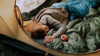 Woman sleeping in a tent