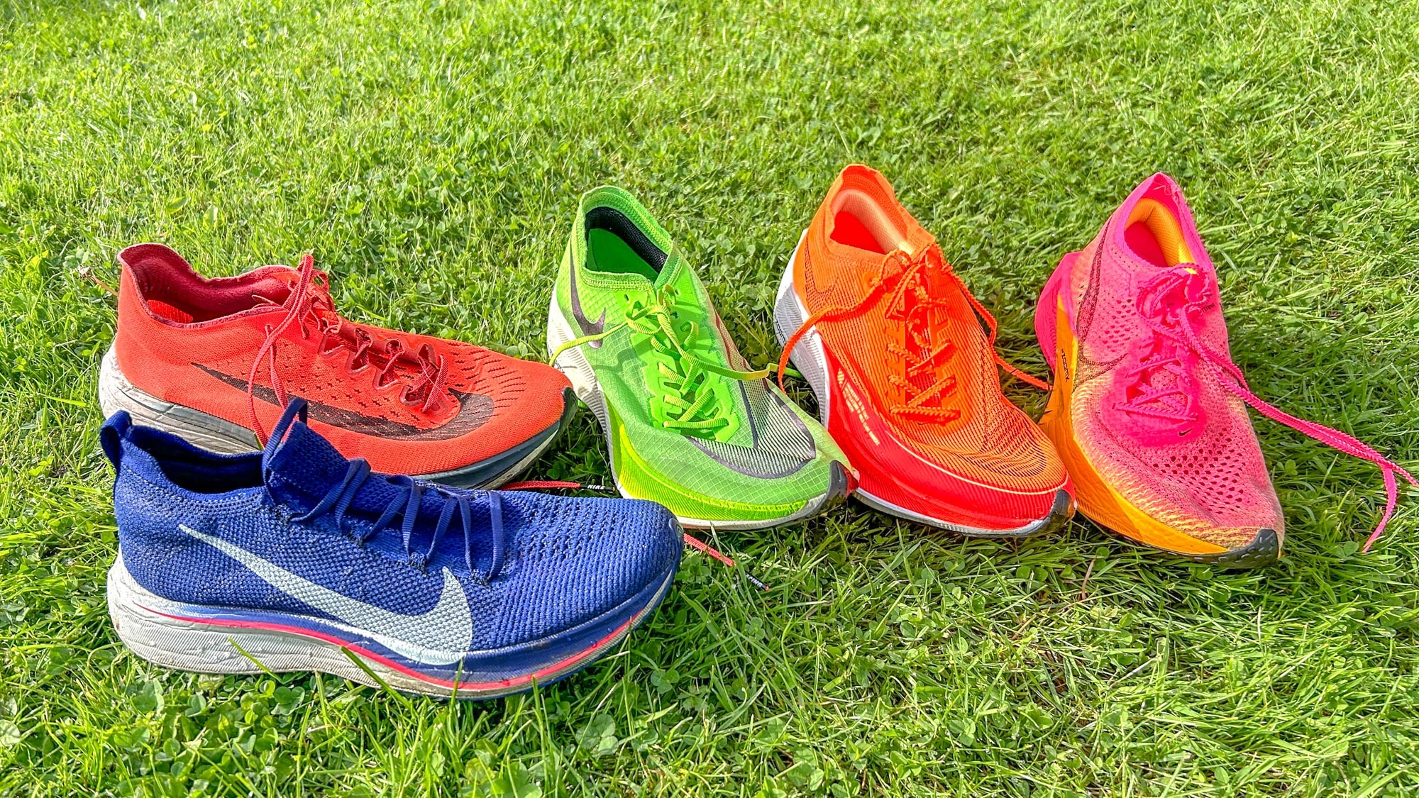 The Nike Vaporfly 4% and several other carbon plate running shoes on some grass