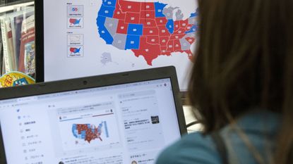 A trader watches an election map as results roll in.