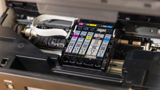 The Canon PIXMA TR7650 inkjet 4-in-1 printer is opened up to reveal its three color and two black inks