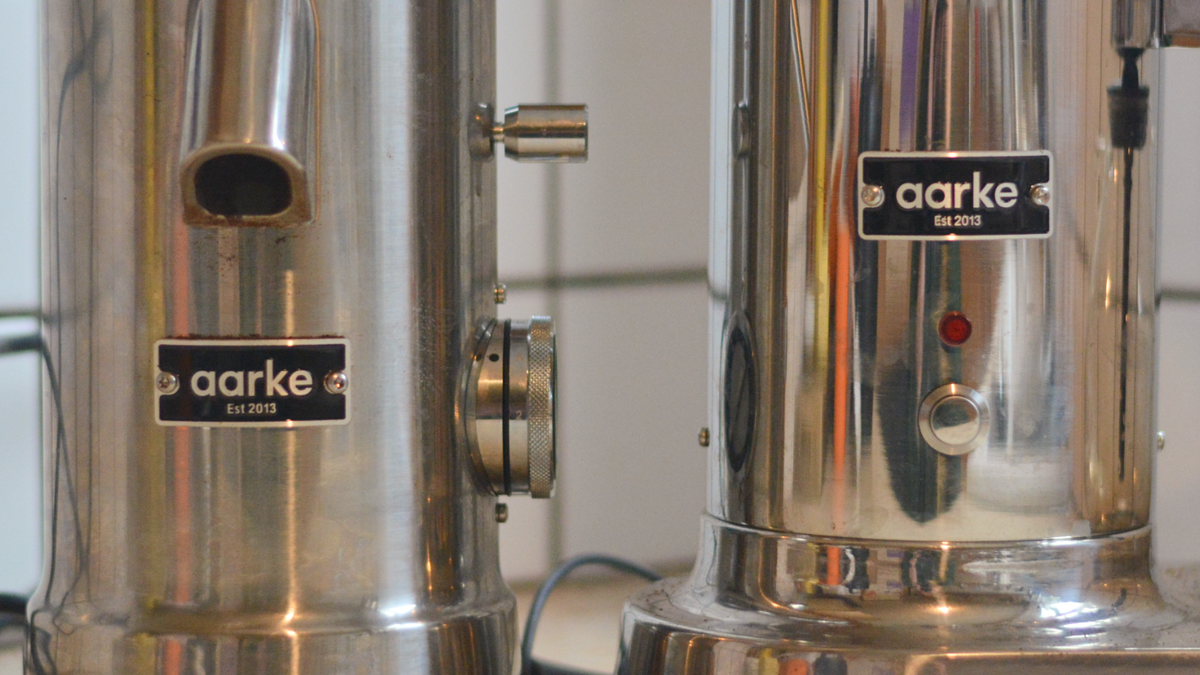 Image of the Aarke Coffee System &ndash; a stainless steel coffee bean grinder and drip coffee maker &ndash; positioned on a kitchen counter