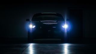 The headlights of a Ford Mustang car in the dark