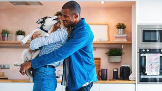 A couple hugging a happy dog