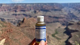 A hiker holding a bottle of Dr Bronner's soap at the Grand Canyon