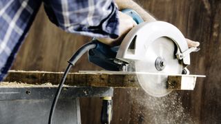 Corded circular saw uses on raw building material