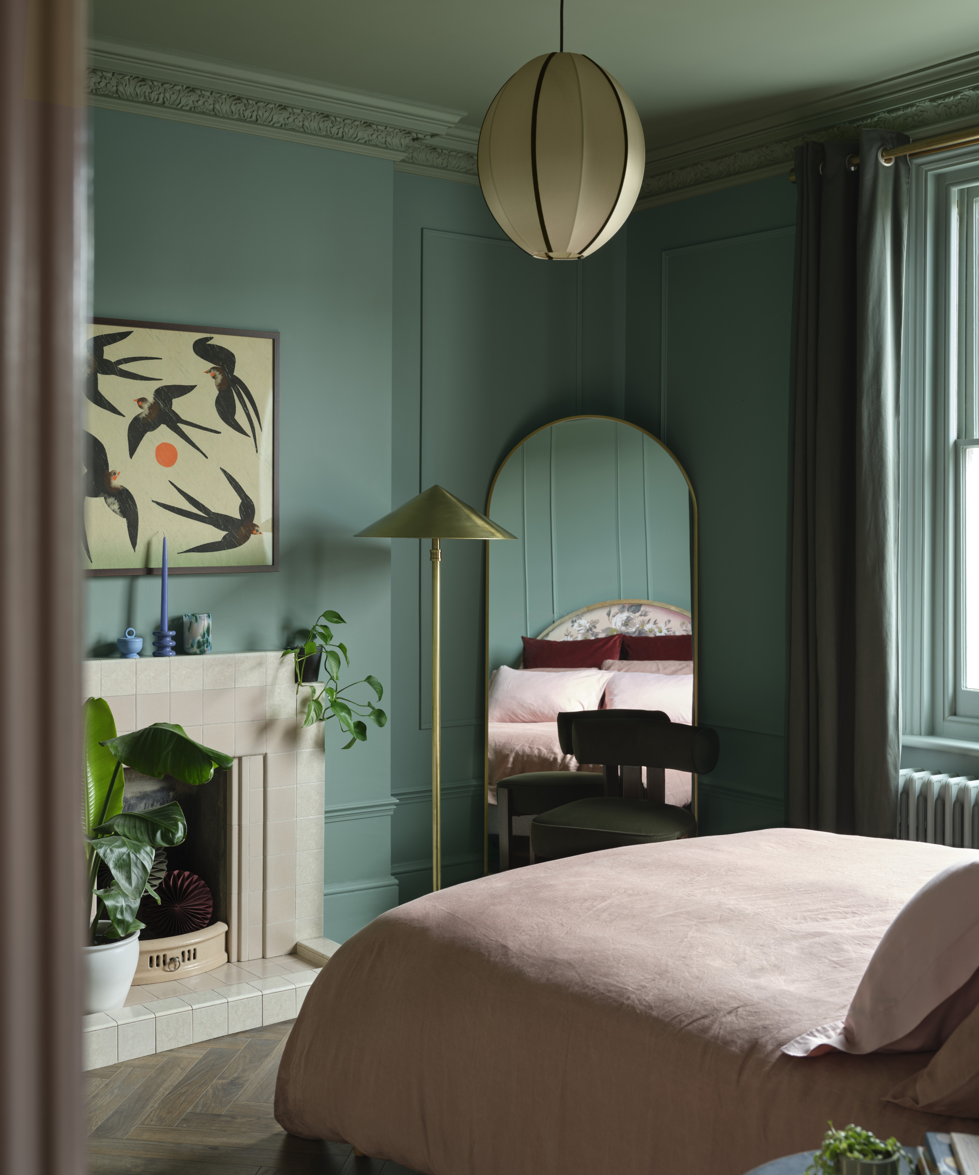bedroom with colour capped green ceiling and walls, pink bedding and cream fireplace