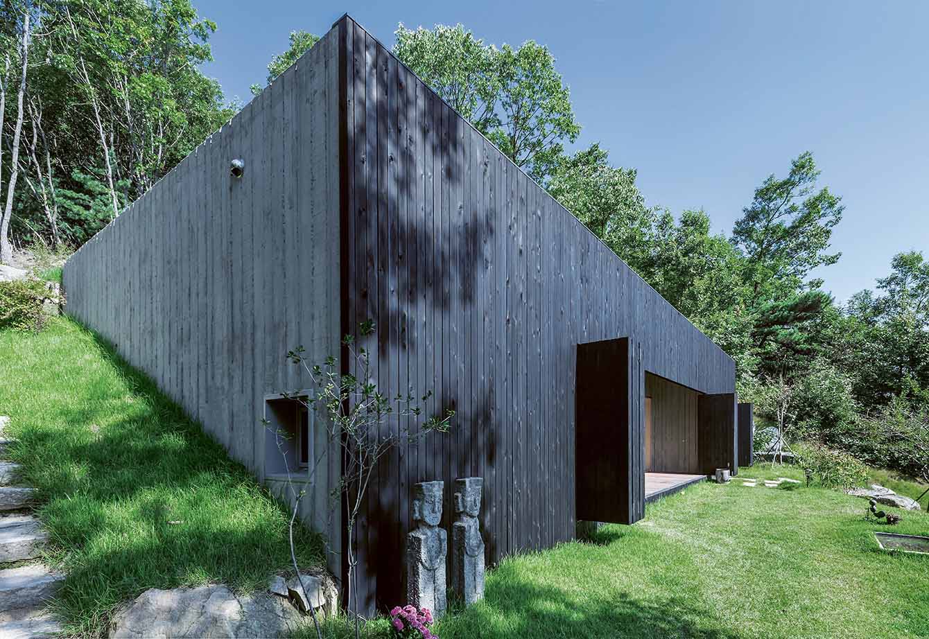 concrete house in countryside featured in Earth Works: Houses by Byoung Cho - Tilt Roof House, 2014