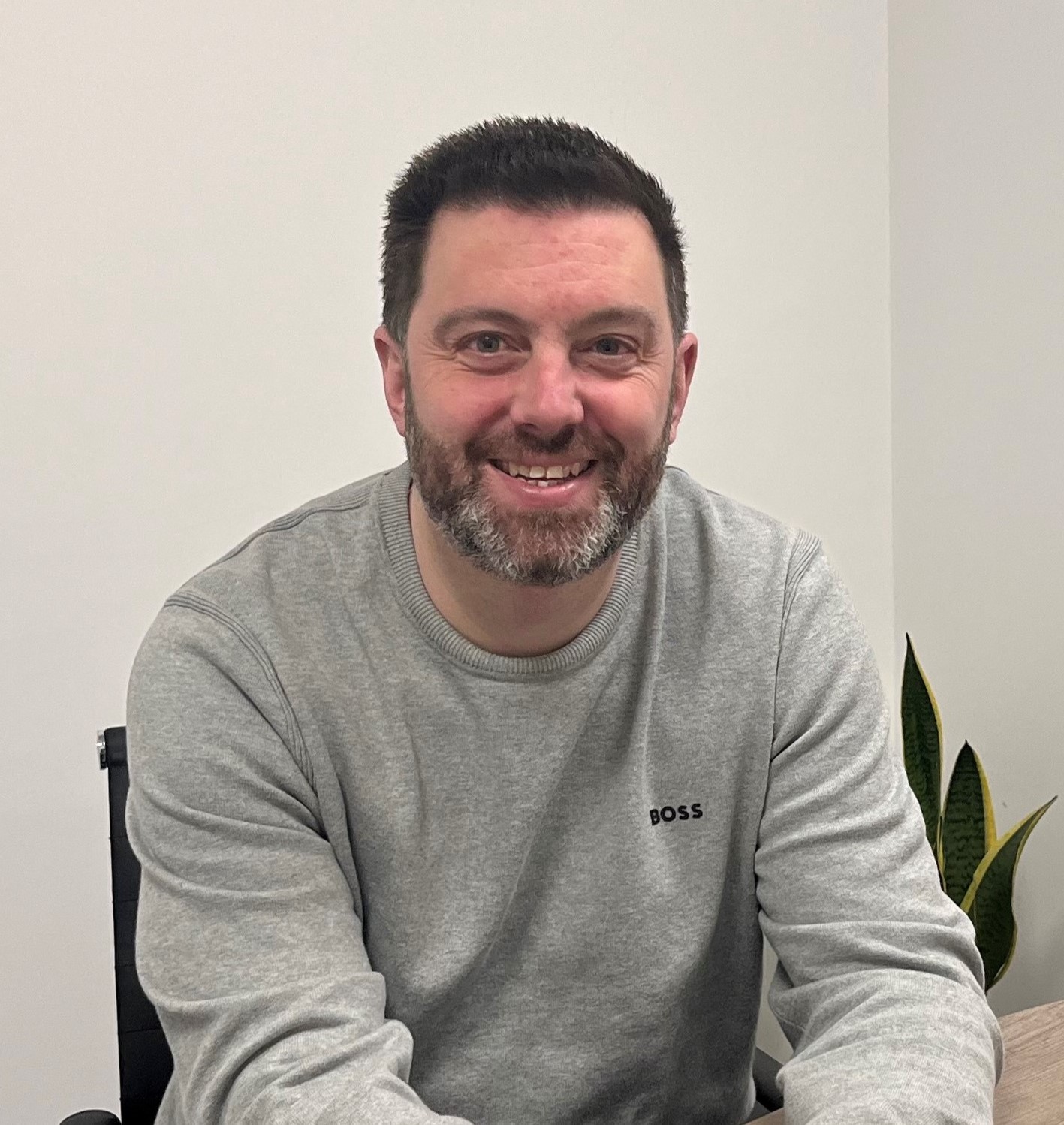 A man with a beard in a grey jumper