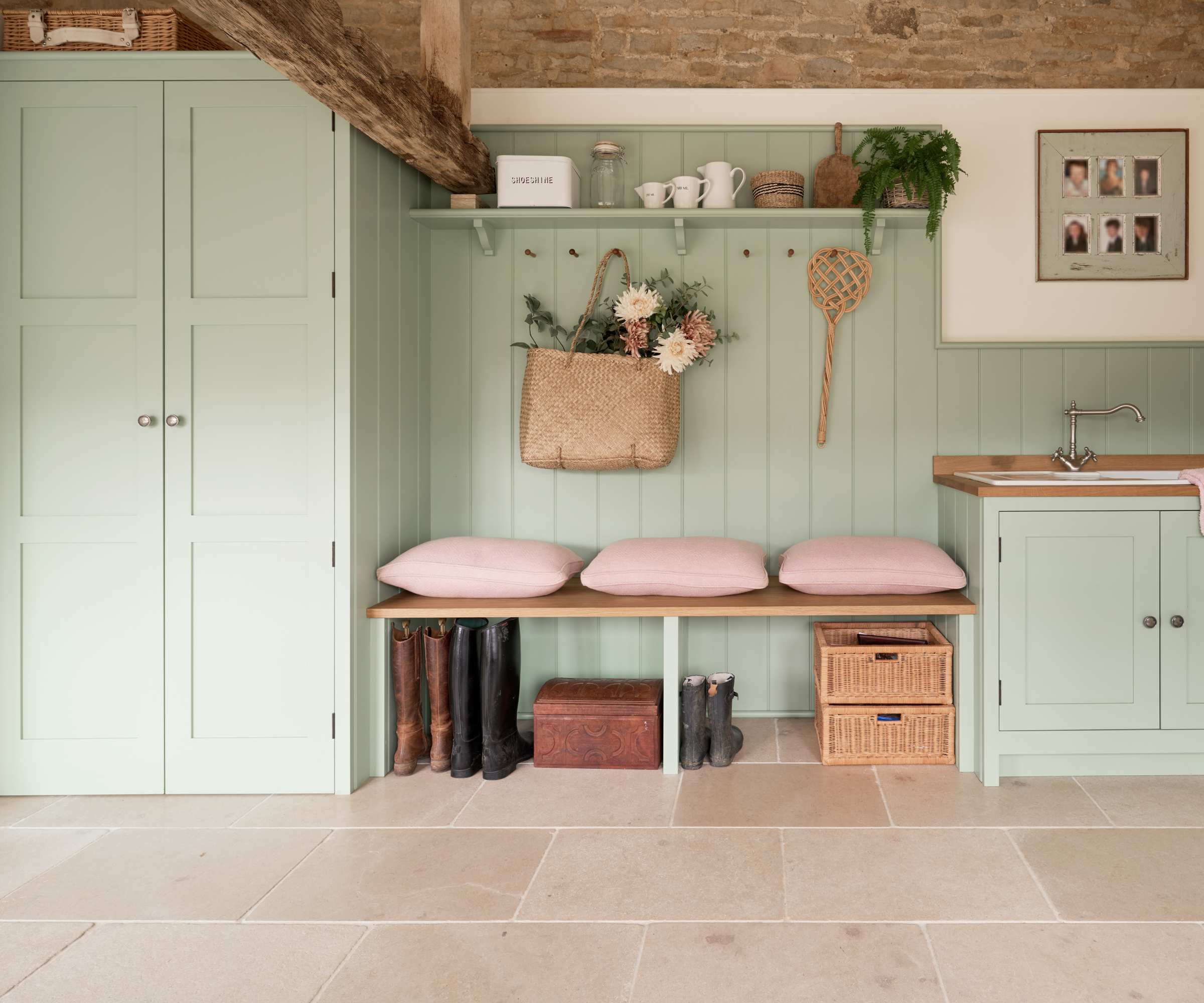 bootility room with large beige floor tiles and pale green cabinets