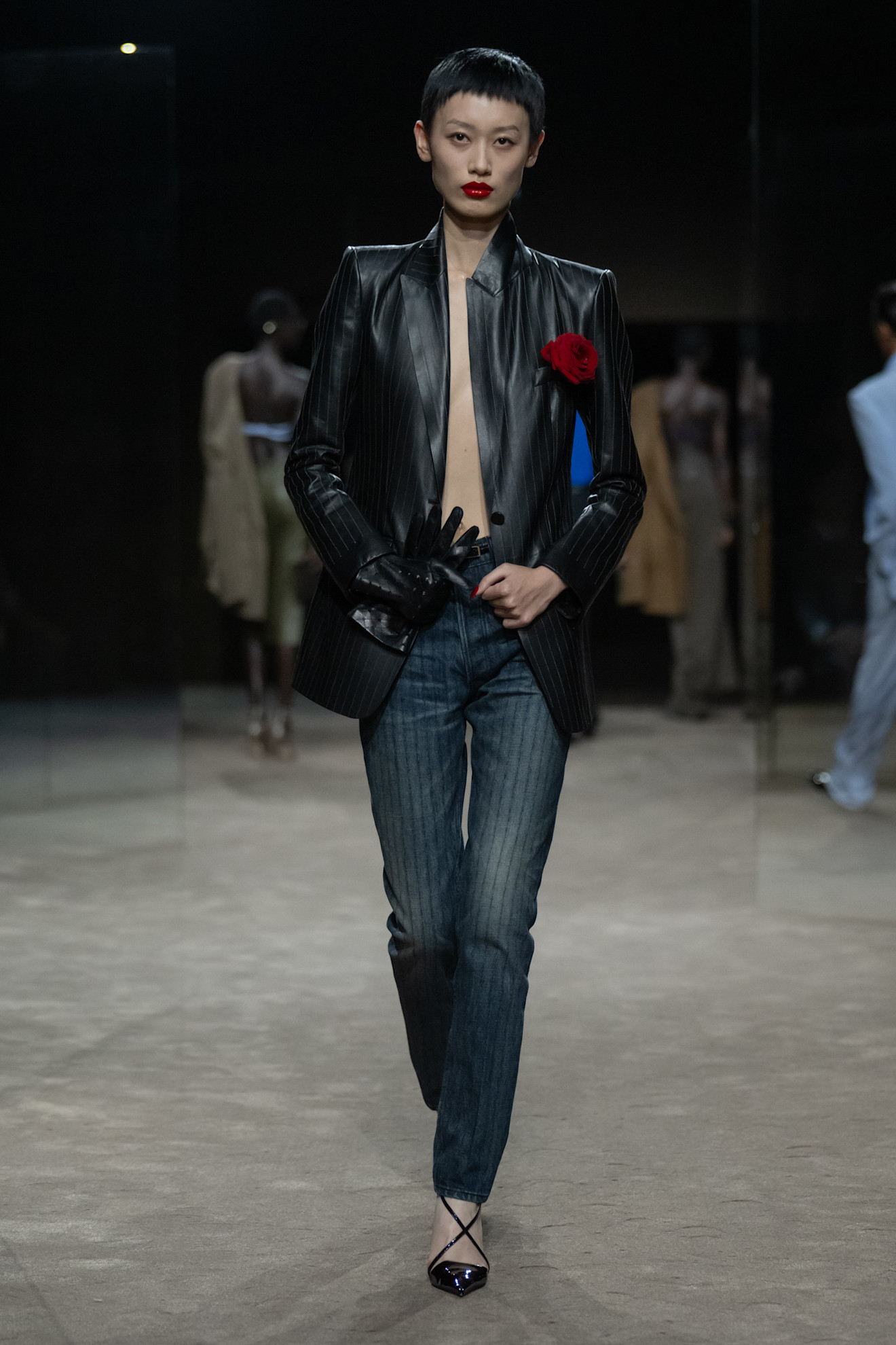 A model wears a rose pinned to the blazer at the tom ford show.