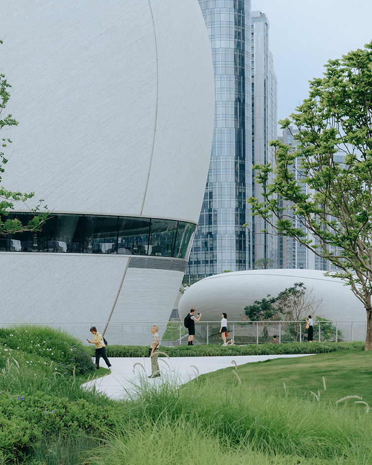 view of MAD Shenzhen Bay Culture Square, all white volumes and curves in a green park