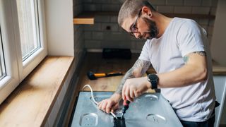 A professional technician repairing an electric stove