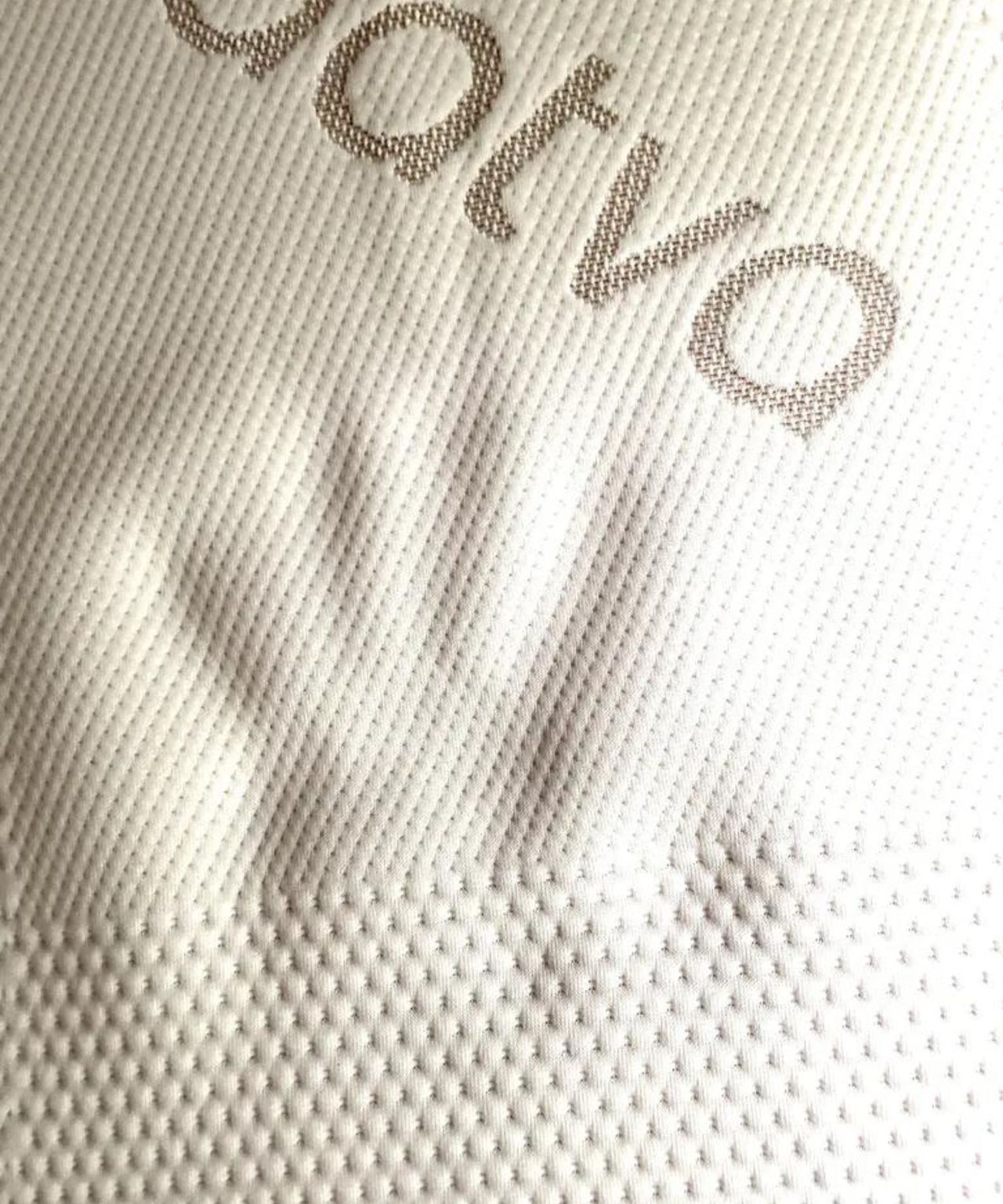 A handprint shown in the Saatva Graphite Mattress Topper, to show the firmness of the topper.