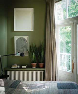 Olive green paint in a bedroom by Farrow & Ball