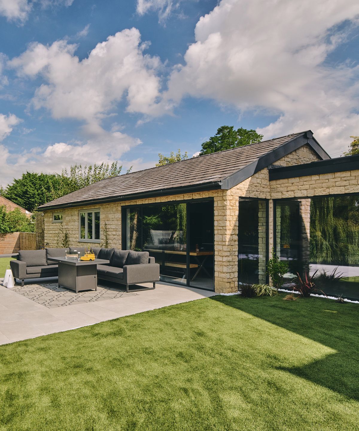 single storey pitched roof extension with large sliding doors and patio seating area