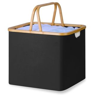 A black fabric laundry basket with a bamboo trim and two matching bamboo basket style handles