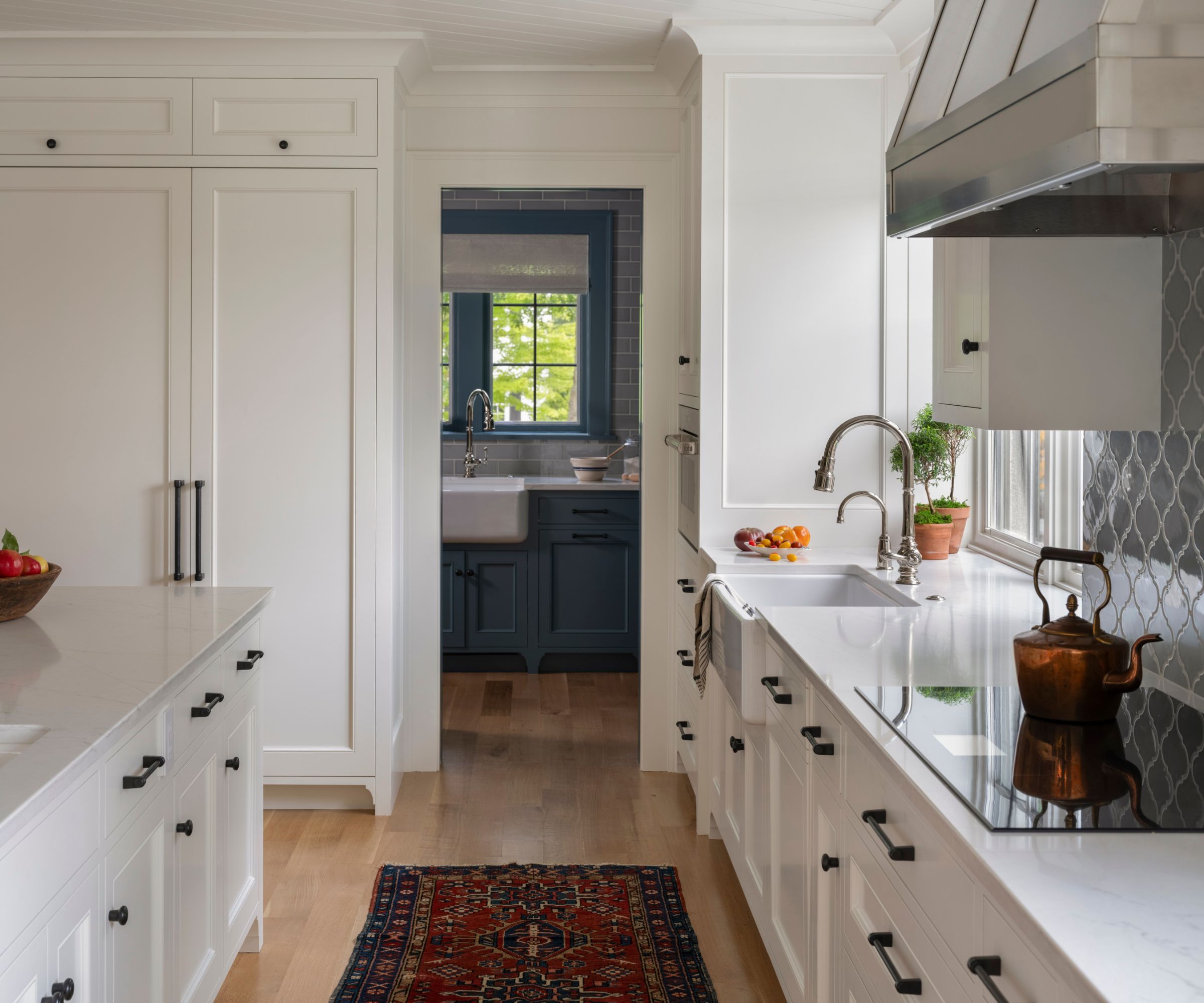 white kitchen with rug and blue tiles